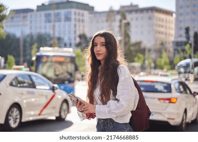 Woman Waiting For Ride Share As Taxi Cabs Drive By In Spain