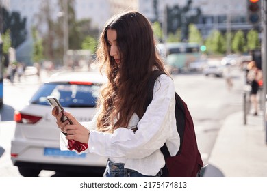 Woman Waiting For Ride Share As Taxi Cabs Drive By In Spain