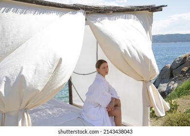 Woman waiting for treatment in spa tent on the beach Massage gazebo overlooking the sea. Spa massage room on the beach.	