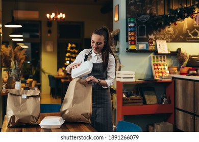 Woman Waitress Preparing Take Away Food In Restaurant