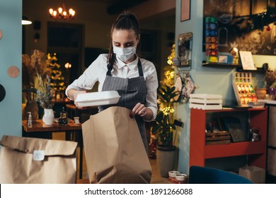 Woman Waitress Preparing Take Away Food In Restaurant