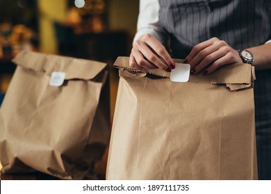 Woman Waitress Preparing Take Away Food In Restaurant