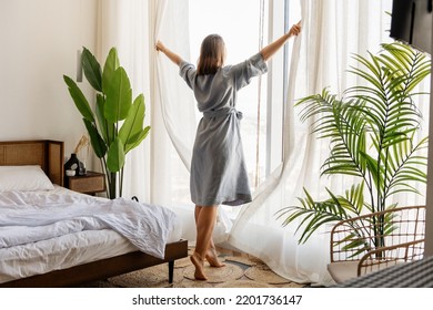 Woman wake up with a fresh and open the curtains on the windows. - Powered by Shutterstock