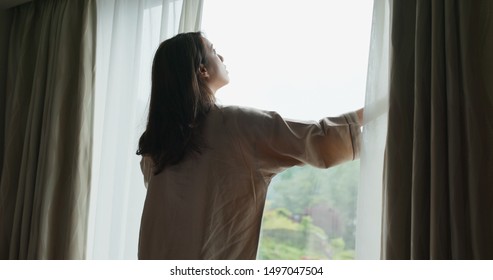 Woman Wake Up At Morning, Open The Curtain And Look Around The View Outside Window