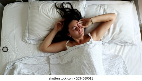 Woman Waking Up In The Morning, Husband Opening Blinds Shining Light Through Window And Lying In Bed With Wife