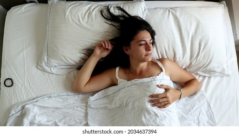 Woman Waking Up In The Morning, Husband Opening Blinds Shining Light Through Window And Lying In Bed With Wife