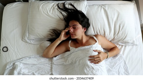 Woman Waking Up In The Morning, Husband Opening Blinds Shining Light Through Window And Lying In Bed With Wife