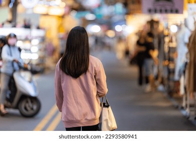 Woman walk into the street night market in Taipei - Powered by Shutterstock