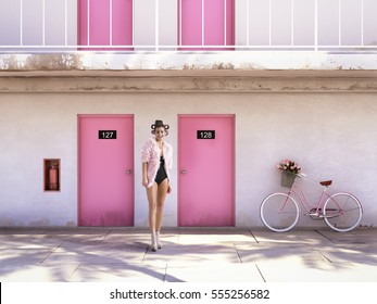 woman walking from abandoned motel with pink doors. Stock Photo