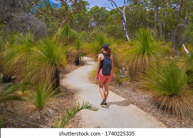 A Woman Walking Along A Forest Path In The Australian Bush