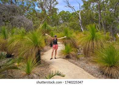 A Woman Walking Along A Forest Path In The Australian Bush