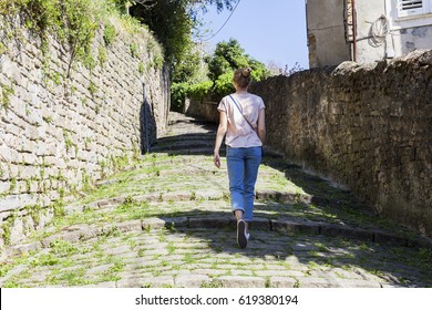 The woman is walking along the old steps overgrown with vegetation. Piran, Slovenija