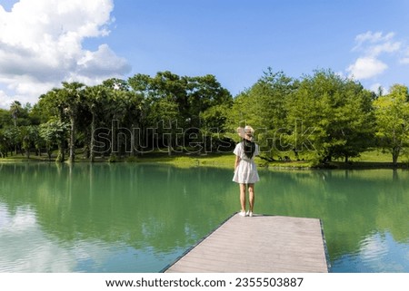 Woman walking along the wooden walkway over the lake