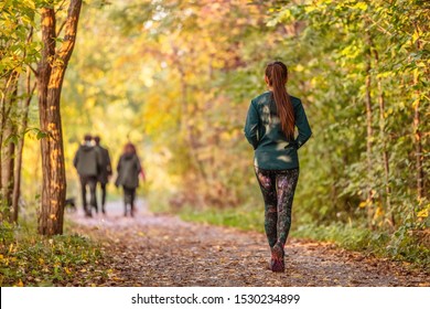 Woman walking in autumn forest nature path walk on trail woods background. Happy girl relaxing on active outdoor activity.