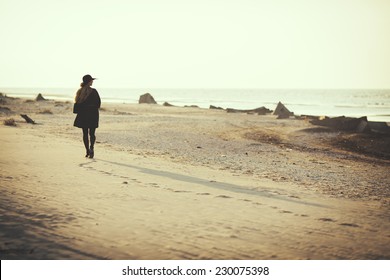 Woman walking away on the beach