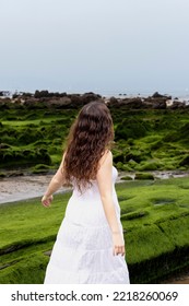 Woman Walking Backwards On The Beach