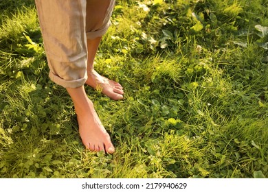 Woman walking barefoot on green grass outdoors, closeup. Space for text - Shutterstock ID 2179940629