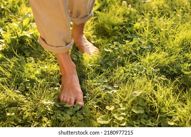 Woman walking barefoot on green grass outdoors, closeup. Space for text - Shutterstock ID 2180977215