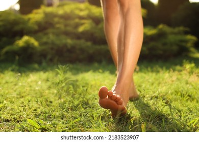 Woman walking barefoot on green grass outdoors, closeup. Space for text - Powered by Shutterstock