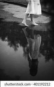 Woman Walking Barefoot Through Puddle Outdoors