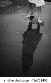 Woman Walking Barefoot Through Puddle Outdoors