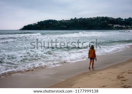 A woman walking at Toninha’s beach in Ubatuba, Sao Paulo, Brazil