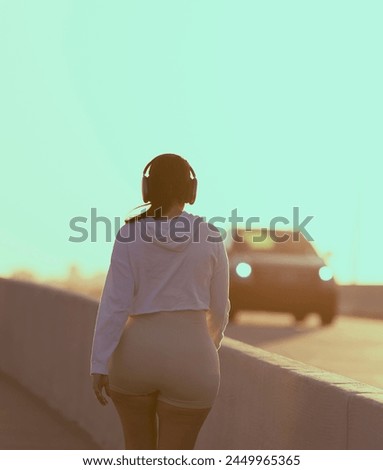 woman walking bridge road street miami listen music

