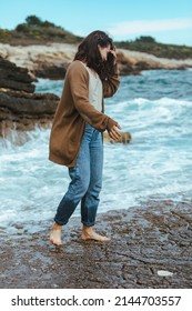 Woman Walking By Rocky Beach In Wet Jeans Barefoot. Summer Sea Vacation