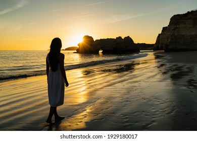 Woman Walking By The Shore Beach In Algarve, Portugal