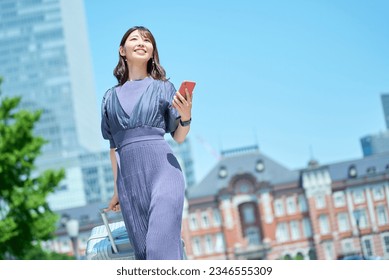 A woman walking in the city with a suitcase