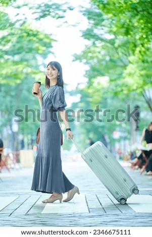 A woman walking in the city with a suitcase