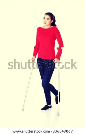 Woman walking with crutches becouse of leg injury