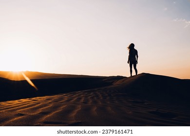 Woman walking in desert at sunset - Powered by Shutterstock