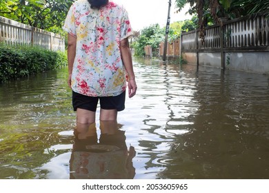 Woman walking in flooding road. Victim of disaster. Flood in North east of Thailand.