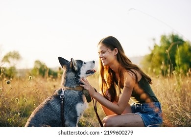 Woman Walking Her Husky Dog And Smiling Happily With Teeth On A Nature Walk On The Grass In The Autumn Sunset, Lifestyle Dog Friend