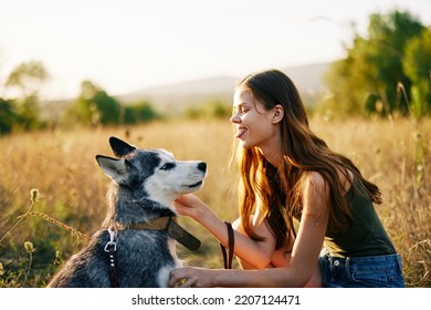 Woman Walking Her Husky Dog And Smiling Happily With Teeth On A Nature Walk On The Grass In The Autumn Sunset, Lifestyle Dog Friend