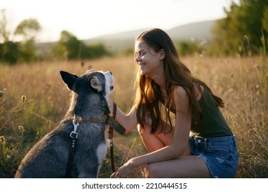 Woman Walking Her Husky Dog And Smiling Happily With Teeth On A Nature Walk On The Grass In The Autumn Sunset, Lifestyle Dog Friend