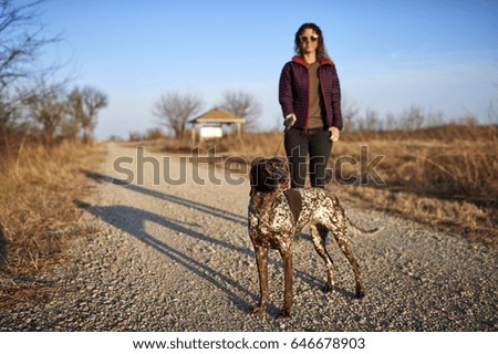 a woman walking her purebred dog