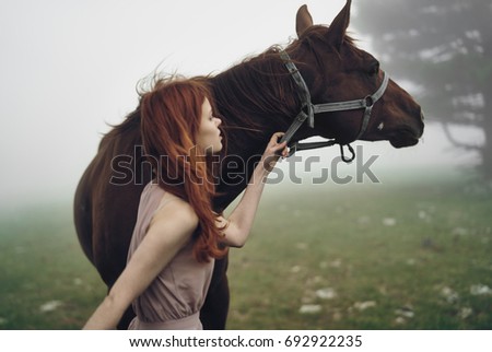 Woman walking with a horse outdoors                               