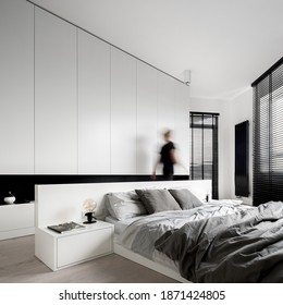 Woman Walking In Luxury Bedroom Interior In Black And White, With Big Bed And Big Wardrobe