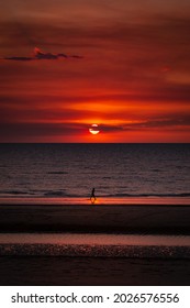 A Woman Walking On The Beach By Sunset In Darwin, Northern Territory, Australia