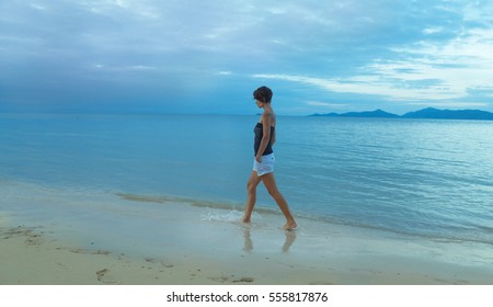 Woman Walking On The Beach One Night.