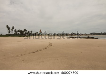 Woman walking on the beach in rainy morning.