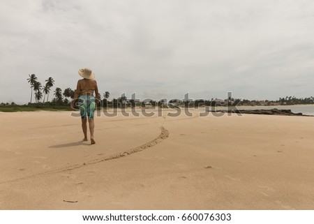 Woman walking on the beach in rainy morning.