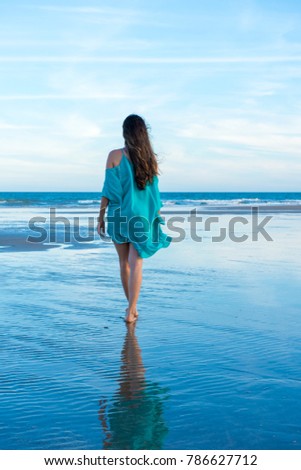 Woman walking on the beach sand