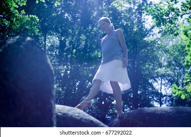 Woman walking on a big roc