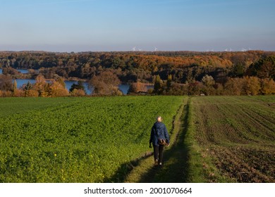 Woman Walking On A Field Path In Rural Autumn Landscape With Soft Hills And Lake District