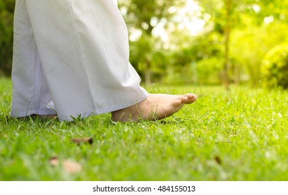 Woman Walking On Green Grass For Relaxation And Meditation