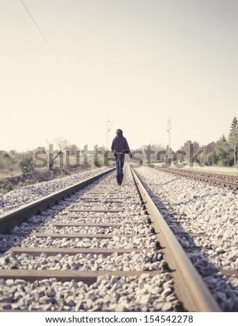 Woman walking on railway tracks