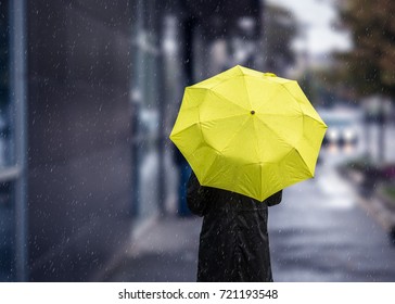 Woman Walking On Rainy Day With Yellow Umbrella